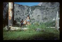 Hikers by waterfall in Glacier National Park