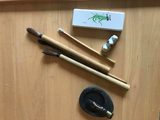 Ink painting tools, top to bottom: paperweight, brush stand, three paint brushes, ink stone and stick