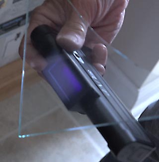 UV light to identify tin residue on one side of a rolled glass sheet